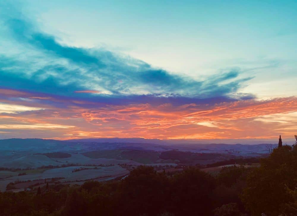 A beautiful sunset over a hilly countryside view.