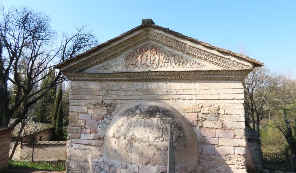 A small temple with a triangular pediment that is richly carved.