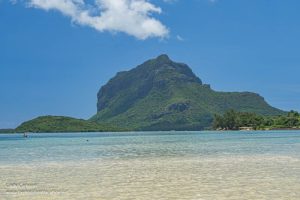 A view of the mountain across a beach and a stretch of water.