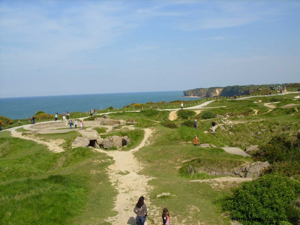 A grassy piece of land above the sea, pockmarked with holes.