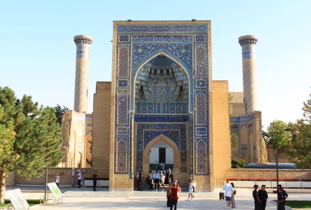 A huge arched entrance with a thin minaret on their side. Around the arch: ornate tile work mostly in blue.