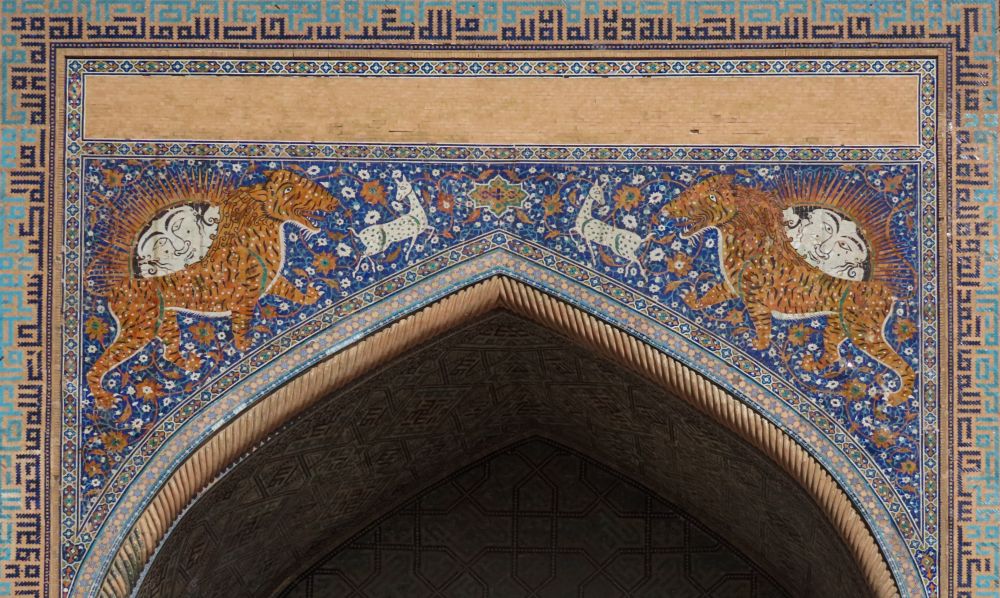 Tilework above an archway shows a lion on either side, with a sun/face peeking out above its back.